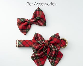 May include: Red Fern Fashions pet accessories. A red, green, and white plaid dog collar with a matching bow tie. The collar has a gold-colored metal ring. The bow tie is separate. The text "Red Fern Fashions Pet Accessories" is at the top.