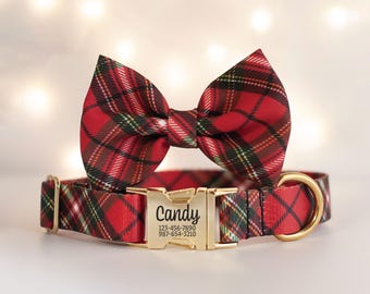 May include: Red plaid dog collar and matching bow tie. The collar has a gold-colored buckle with the name "Candy" and a phone number. The bow tie is a classic bow shape. The background is blurred with soft, out-of-focus lights.