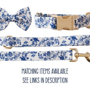 May include: A matching dog collar, leash, and bow tie set. The set features a white background with a blue floral pattern. The collar has a gold buckle, and the leash has a gold clasp. The bow tie is pre-tied. The text "MATCHING ITEMS AVAILABLE SEE LINKS IN DESCRIPTION" is at the bottom.