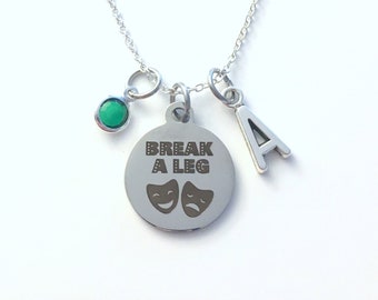 Puede incluir: Collar de plata con un dije que dice "Break a Leg" con dos máscaras de teatro, un pequeño dije de piedra preciosa verde y un dije de plata con la letra "A".