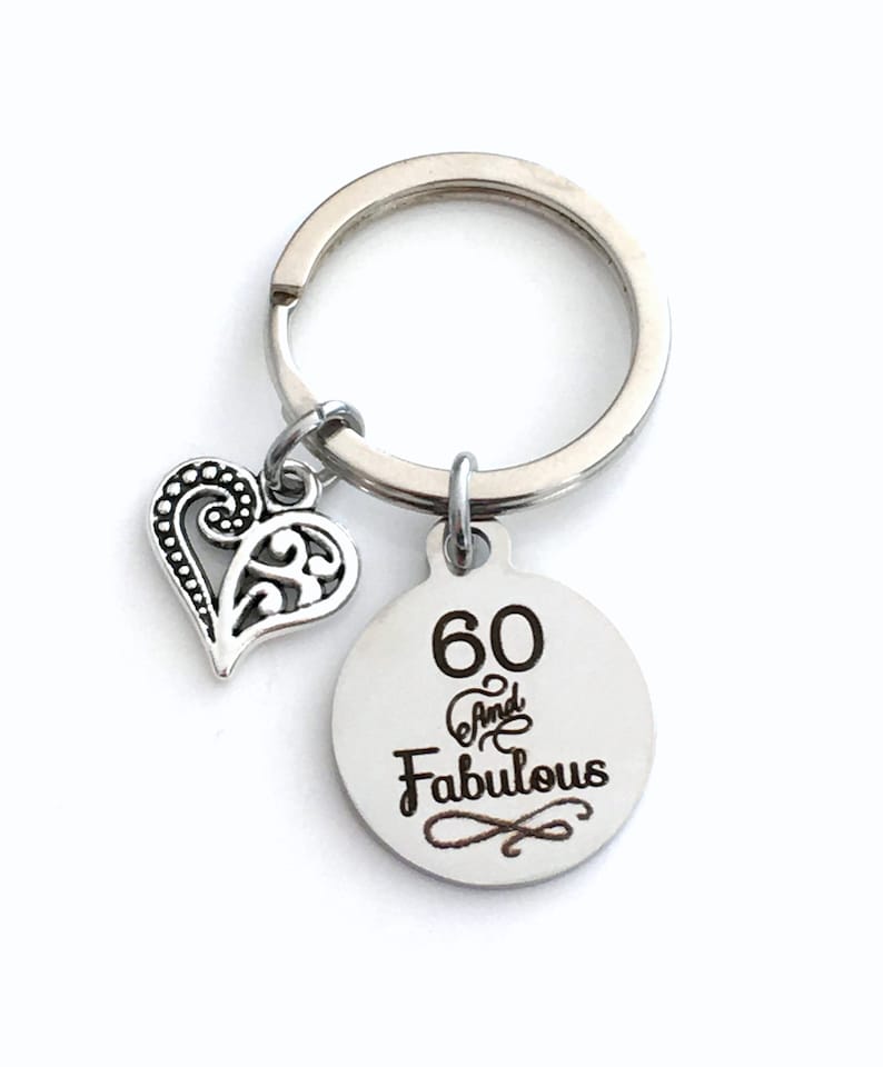 Pode incluir: Chaveiro de prata com um charme de cora&ccedil;&atilde;o e uma etiqueta redonda que diz "60 And Fabulous".
