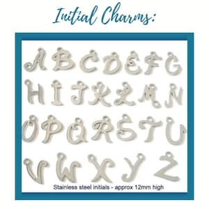 May include: A collection of silver-toned metal initial charms featuring the letters A through Z in a cursive script font. Each charm includes a small circular loop at the top for attachment. The text Initial Charms and Stainless steel initials - approx 12mm high is visible.