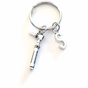 May include: Silver keychain with a dental drill charm and a letter 'S' charm.