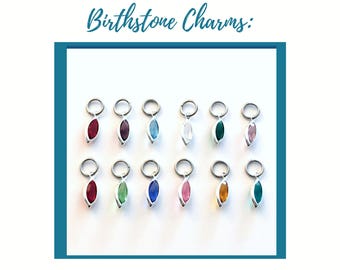 May include: Twelve marquise-cut birthstone charms arranged in two rows, each featuring a silver-toned jump ring and a faceted colored gemstone. The text Birthstone Charms: is displayed in blue script at the top of the image above the charms.