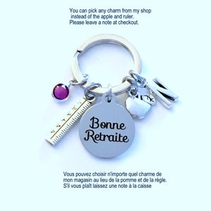 May include: Silver keychain with multiple charms, including a purple gem, a ruler, a round tag with "Bonne Retraite" text, an apple, and the letter "N". The text on the image says "You can pick any charm from my shop instead of the apple and ruler. Please leave a note at checkout."