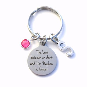 May include: Silver keychain with a pink gem, a letter 'S' charm, and a round tag that reads "The love between an Aunt and Her Nephew is Forever".