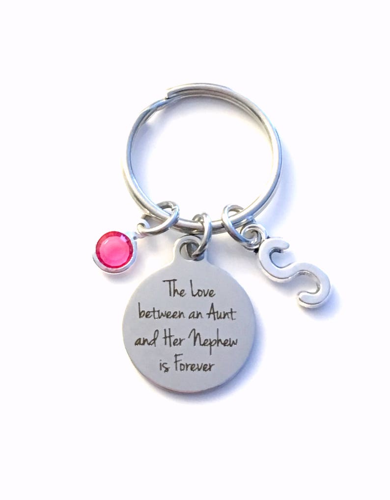 May include: Silver keychain with a pink gem, a letter 'S' charm, and a round tag that reads "The love between an Aunt and Her Nephew is Forever".