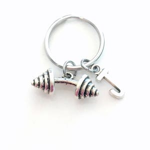 May include: Silver dumbbell keychain with a letter J charm. The dumbbell is detailed with a textured design.