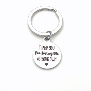 May include: Silver keychain with a round tag that says "Thank You For Loving Me As Your Own" with a small heart at the bottom.