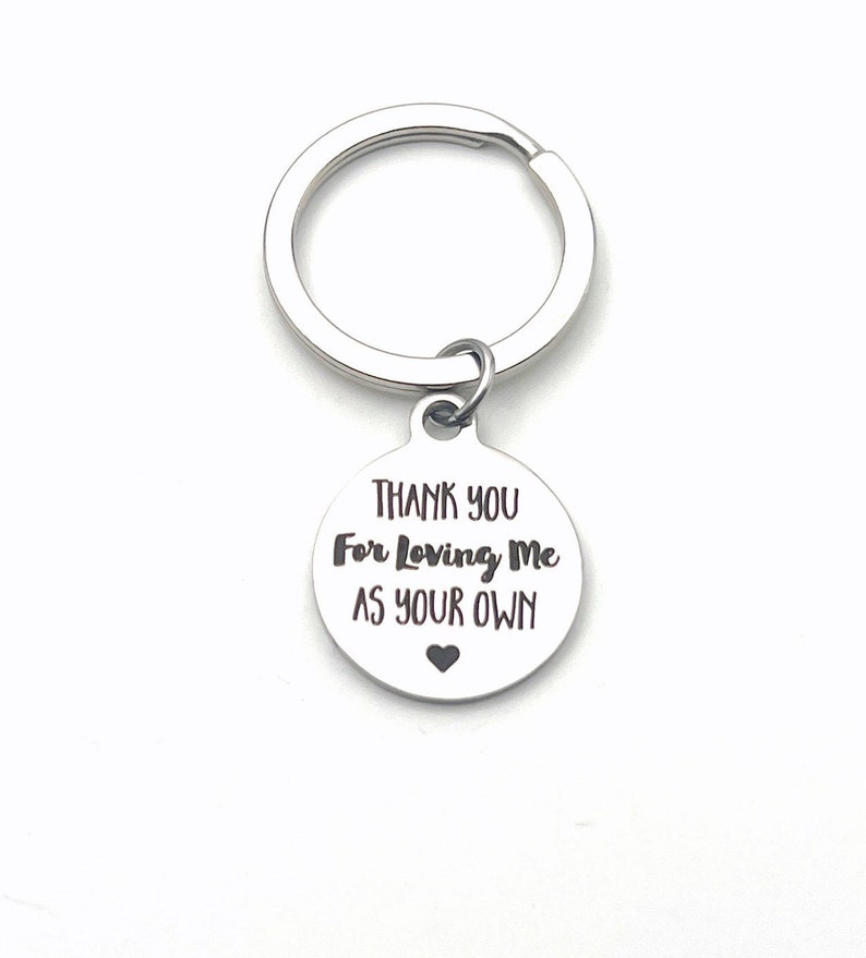 May include: Silver keychain with a round tag that says "Thank You For Loving Me As Your Own" with a small heart at the bottom.