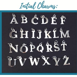 May include: A collection of silver-toned metal initial charms arranged in alphabetical order from A to Z. Each letter features a small circular jump ring at the top for attachment. The text "Initial Charms:" is displayed above the letters.