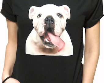 Op de afbeelding: Een zwart T-shirt met een witte bulldog geprint op de voorkant. De bulldog heeft zijn tong uitgestoken en kijkt recht in de camera.
