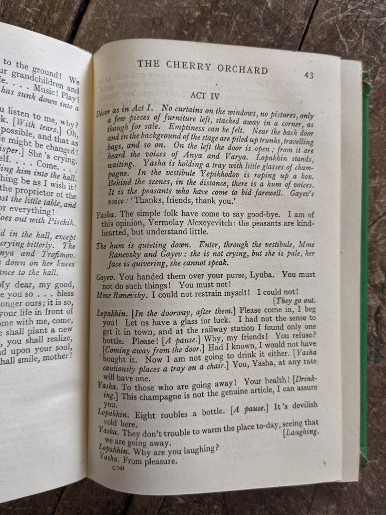 May include: A vintage book with a worn cover, titled "The Cherry Orchard" by Anton Chekhov. The book is open to page 43, showing Act IV of the play. The text is in black and white, with a few illustrations.