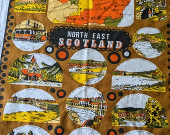 Pode incluir: Uma toalha de chá marrom com um mapa do nordeste da Escócia e ilustrações de vários marcos. O mapa mostra as regiões de Nairn, Inverness, Moray, Banff, Aberdeen, Angus e Kincardine. Os marcos incluem a Catedral de Elgin, Tomintoul e a Universidade de Aberdeen.
