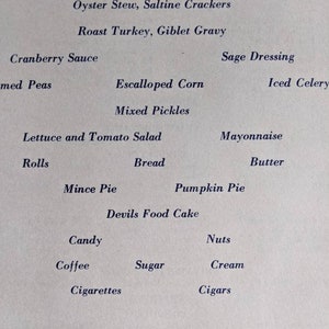 May include: A vintage menu printed on cream-colored paper. The menu lists various dishes, including Oyster Stew, Roast Turkey, and Pumpkin Pie. The text is in a classic serif font. The menu is signed by Mess Sergeant Sgt. Charles E. Reed.