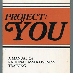 May include: A book cover with an orange background and black text that reads "PROJECT: YOU" and "A MANUAL OF RATIONAL ASSERTIVENESS TRAINING". The book is by Claudine Paris & Bill Casey with a foreword by Michael J. Mahoney.