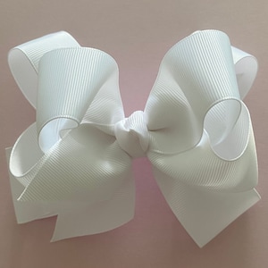 May include: A large white satin bow with a center knot. The bow is made of a soft, silky material and has a classic, elegant look.
