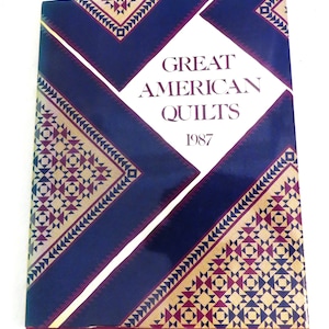 May include: A book titled "Great American Quilts 1987" with a blue, gold, and red patterned cover.
