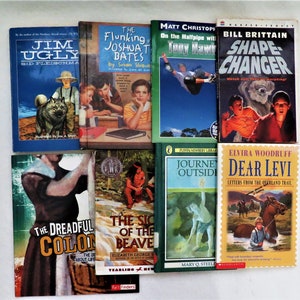 May include: A collection of ten paperback books with various titles and authors. The books are arranged in two rows, with five books in each row. The books are all different colors and have different illustrations on the covers.