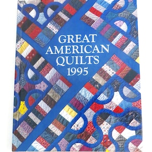 May include: A blue book with a quilt pattern on the cover. The title is "Great American Quilts 1995".
