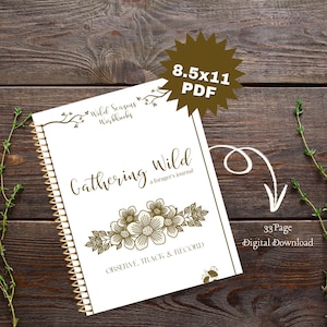 Könnte beinhalten: Ein weißes Journal mit einer goldenen Spiralbindung und einem floralen Design auf dem Cover. Der Text auf dem Cover lautet "Gathering Wild, a forager's journal" und "Observe, Track & Record". Das Journal liegt auf einer Holzoberfläche. Der Text "8.5x11 PDF" und "33 Page Digital Download" ist ebenfalls sichtbar.