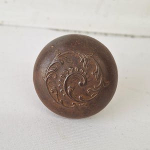 May include: A white ceramic mug with a black handle and the text "But First, Coffee" in a black, handwritten-style font. The mug is on a white surface.