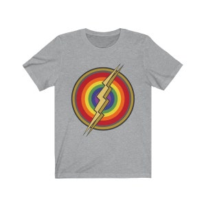 May include: A grey t-shirt with a rainbow and lightning bolt design. The design is in the center of the shirt and is a stylized version of the Flash logo.