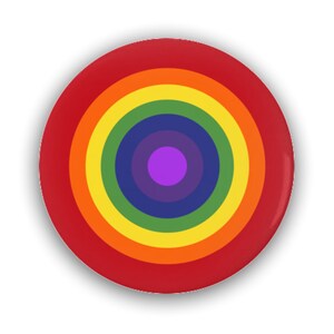 May include: A round button with a rainbow concentric circle design. The center circle is purple, surrounded by a dark blue circle, then a light blue circle, then a green circle, then a yellow circle, then an orange circle, then a red circle. The outer circle is red.