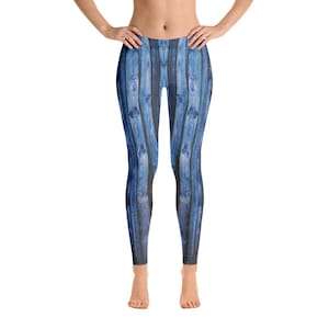 May include: Blue leggings with a wood grain pattern. The leggings feature a vertical plank design in shades of blue and black, creating a textured appearance. The leggings are form-fitting and reach to the ankles.