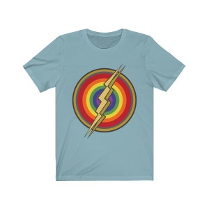 May include: A light blue t-shirt with a rainbow circle and a gold lightning bolt graphic.