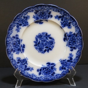 May include: Blue and white porcelain plate with a floral design. The plate has a scalloped edge and a raised rim.