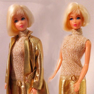 May include: Two blonde dolls wearing gold dresses. One doll is wearing a gold jacket over her dress. Both dolls are wearing gold shoes.