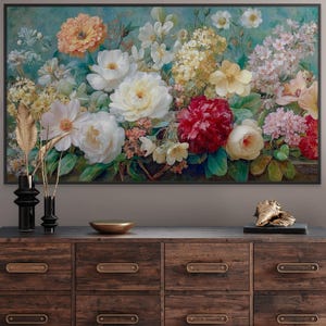 May include: A framed floral painting featuring a vibrant arrangement of white, yellow, orange, and red flowers against a teal background. The artwork is displayed above a wooden dresser with decorative items.