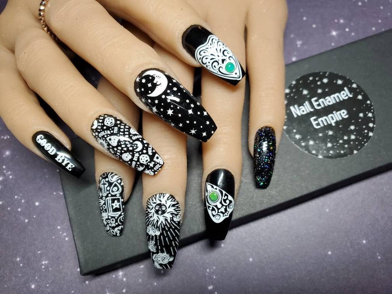 May include: Black and white nail art with a variety of designs, including a crescent moon, stars, a sun, a pentagram, and the words "Good Bye".