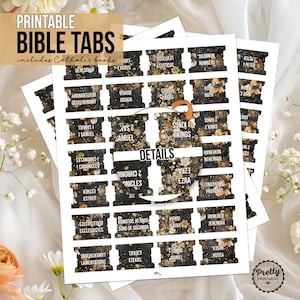 May include: Printable Bible tabs with gold and black floral designs. The tabs include the names of the books of the Bible, including Catholic books.
