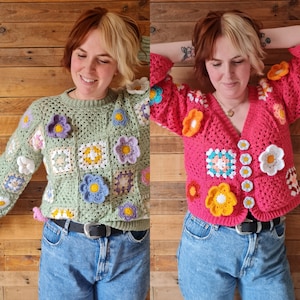 Pode incluir: Duas mulheres vestindo cardigãs de crochê com desenhos florais. Um cardigã é verde com flores brancas e rosas, o outro é rosa com flores laranja, amarelas e brancas. Ambas as mulheres estão usando jeans azul.