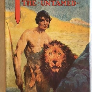 May include: A vintage book cover featuring a color illustration of Tarzan, a muscular man with a lion, against a yellow and brown background. The title "Tarzan the Untamed" is printed in red letters. The author's name, "Edgar Rice Burroughs", is printed in gold letters at the bottom of the cover.
