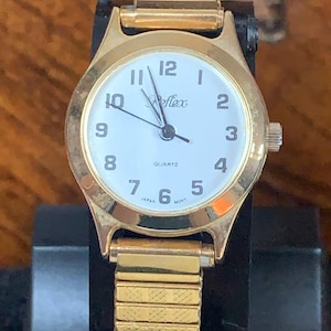 A simple no fuss Ladies Reflex  white face watch Gold tone
