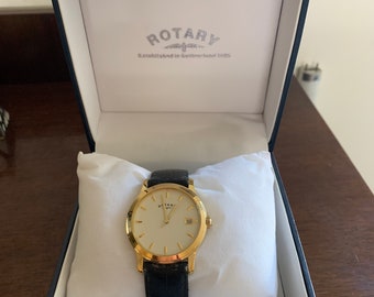 Reloj Rotary para caballero con esfera color crema y acabado dorado, con fecha, en caja Rotary.