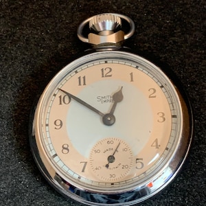 Reloj de bolsillo Smiths Empire para hombre, esfera gris/plateada, caja abierta, chapado en cromo, circa 1964.