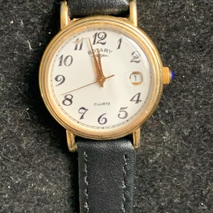 Klassiek draaihorloge met witte wijzerplaat, datum en Arabische cijfers zoals gevonden
