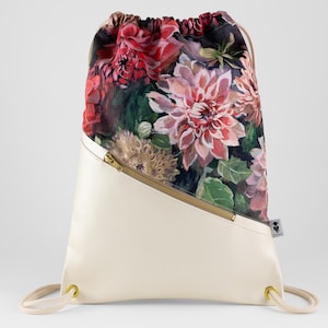 Può includere: Zaino con coulisse con un motivo floreale di fiori rosa, rossi e verdi. La parte inferiore è color crema con una cerniera dorata e una chiusura con coulisse. Ha occhielli dorati e coulisse color crema.