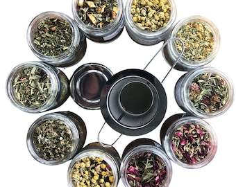 May include: A set of ten glass jars filled with various dried herbs and flowers. The jars are arranged in a circle around a metal tea infuser.