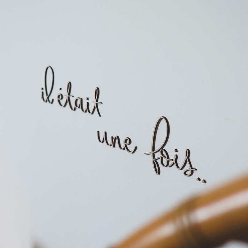 Op de afbeelding: Een witte achtergrond met de Franse zin "il &eacute;tait une fois..." geschreven in zwarte cursieve letters.