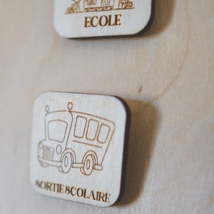 May include: A wooden sign with a cartoon school bus and the text "SORTIE SCOLAIRE" in French.