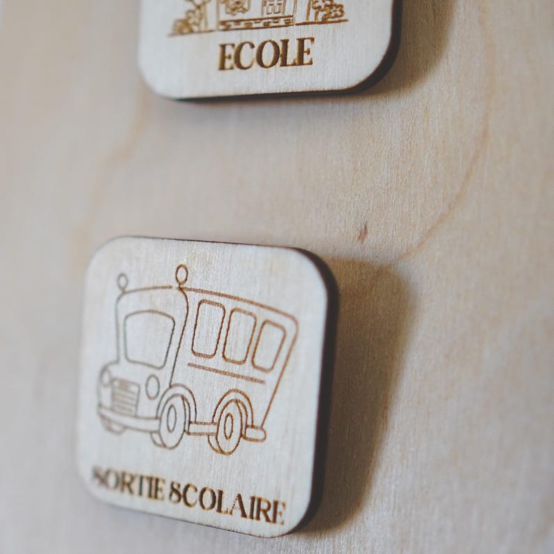 May include: A wooden sign with a cartoon school bus and the text "SORTIE SCOLAIRE" in French.