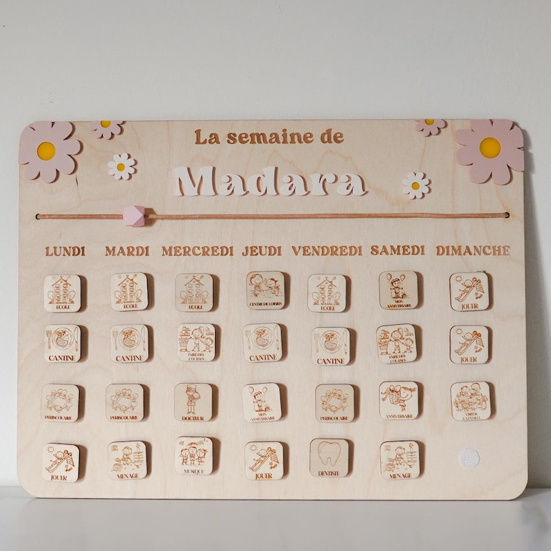Pu&ograve; includere: Un grafico settimanale in legno per un bambino di nome Madara. Il grafico ha i giorni della settimana etichettati in francese: Lundi, Mardi, Mercredi, Jeudi, Vendredi, Samedi, Dimanche. Ogni giorno ha quattro slot per le attivit&agrave;, con immagini di attivit&agrave; come la scuola, la mensa, il gioco e il dentista.