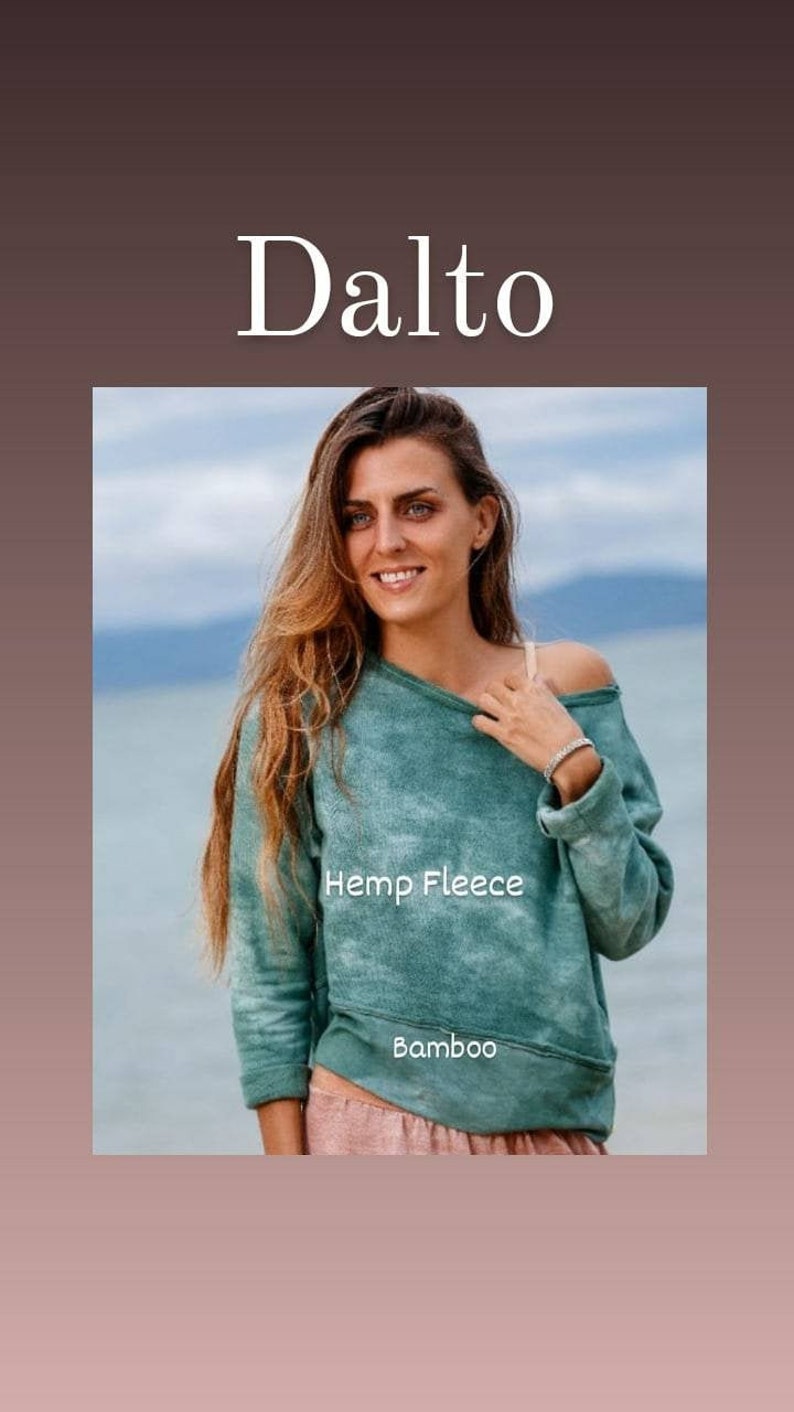 May include: A woman wearing a green hemp fleece and bamboo blend sweatshirt with a tie-dye pattern. The sweatshirt has a relaxed fit and a scoop neck.