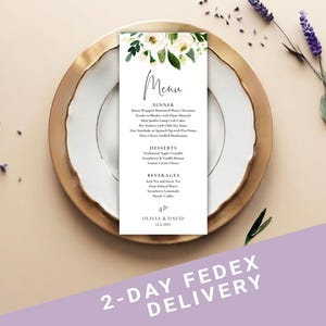 May include: A vertical white menu card featuring a floral illustration of white roses and green leaves at the top. The text includes the word Menu, sections for Dinner, Desserts, and Beverages, and the names Olivia & David with the date 12.6.2027.