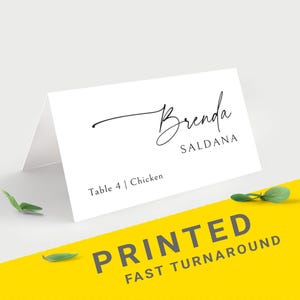 Pu&ograve; includere: Un segnaposto bianco con il nome "Brenda Saldana" in elegante scrittura nera. La carta include anche "Table 4 | Chicken" e il testo "PRINTED FAST TURNAROUND" su sfondo giallo. Il design 5 si trova nell'angolo in alto a sinistra.